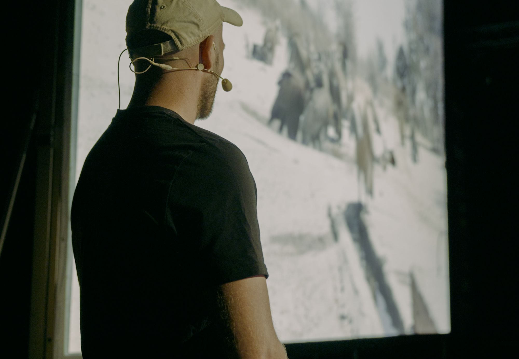 Valentin Grüner on stage with a headset microphone in front of a large projection screen